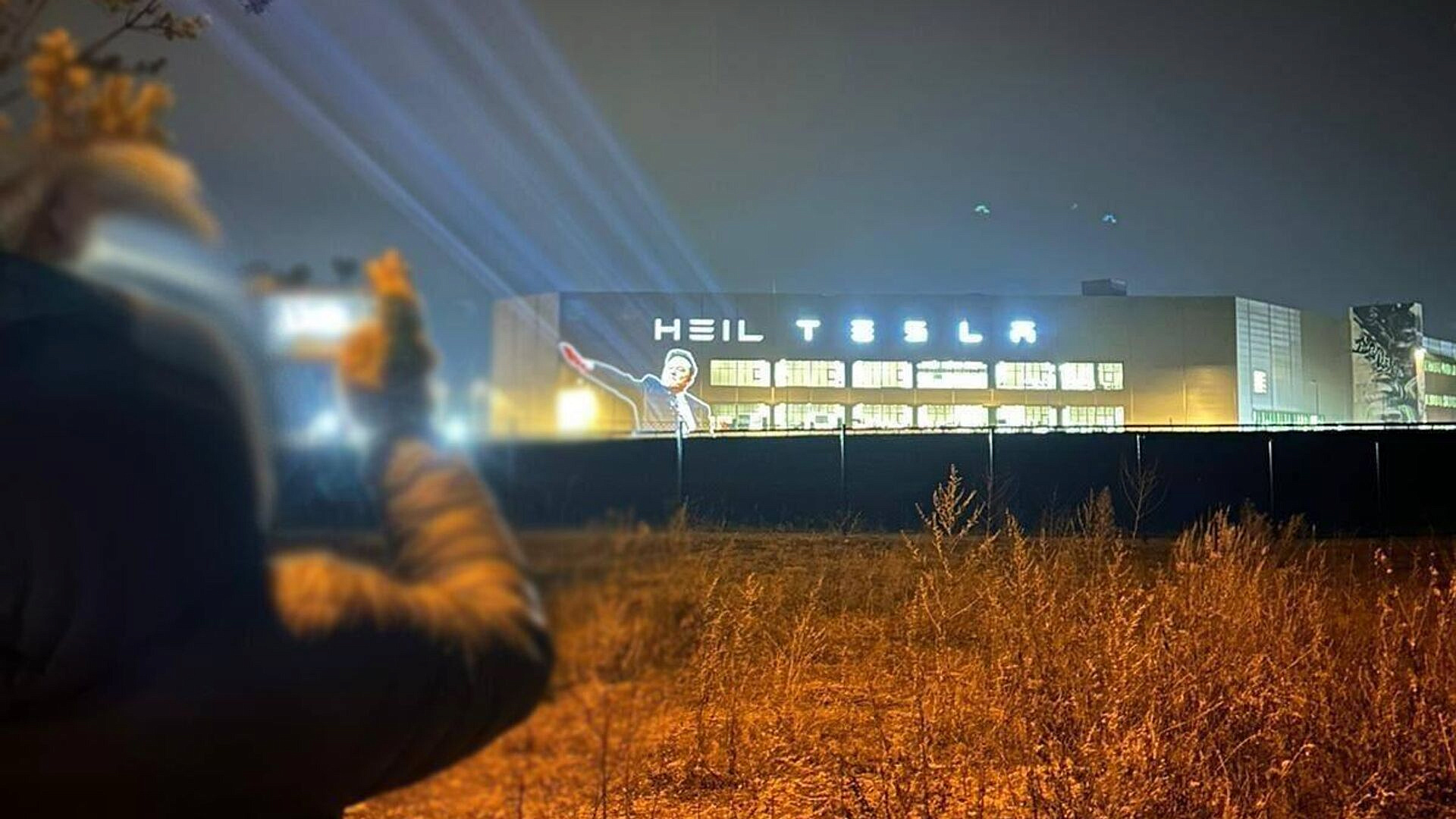 На фасад завода Tesla в Берлине вывели проекцию с жестом Маска